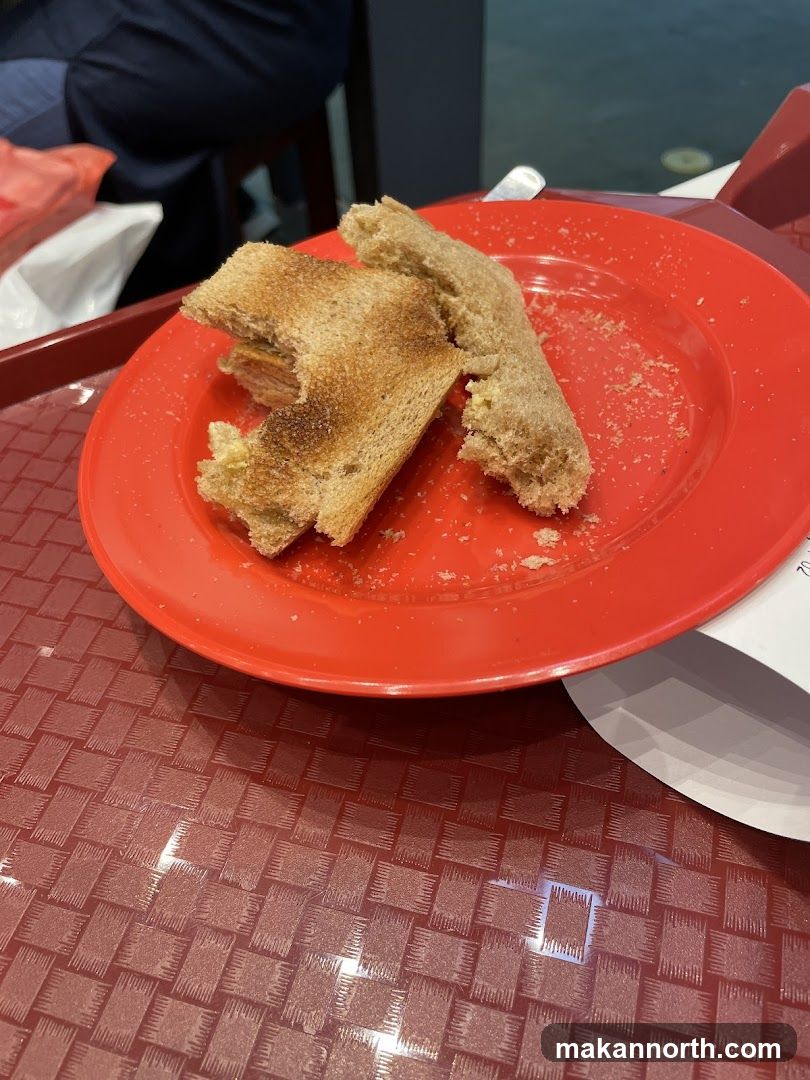 Half-eaten sandwich on a red plate