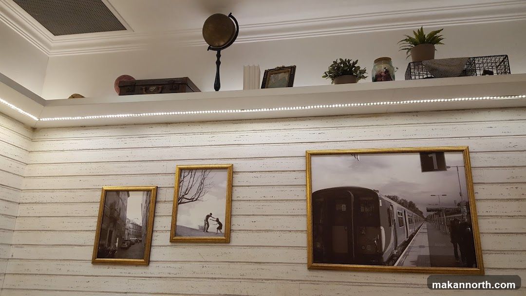 Decorated wall with framed pictures and shelf items