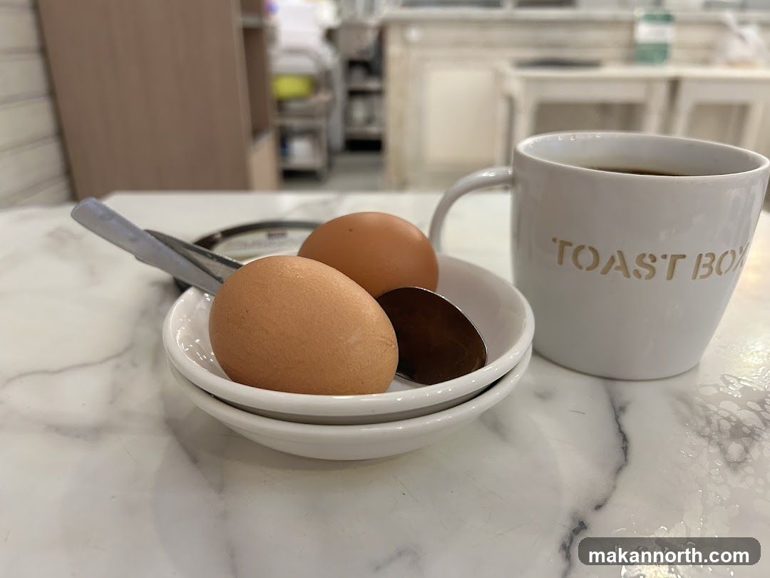 Two soft-boiled eggs and a mug of coffee