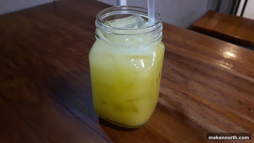 Glass of yellow drink with ice