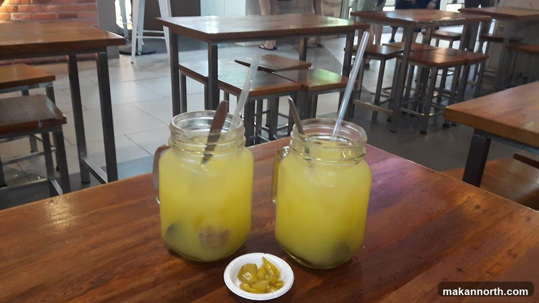 Two Glasses of Yellow Drink with Pickles