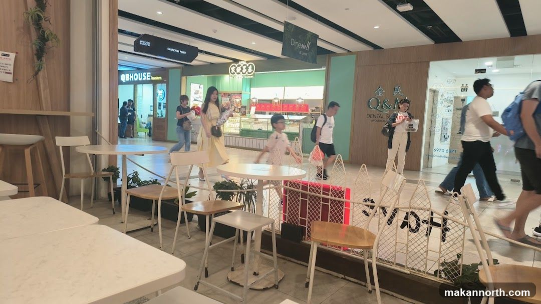 Indoor mall walkway with seating areas and shops