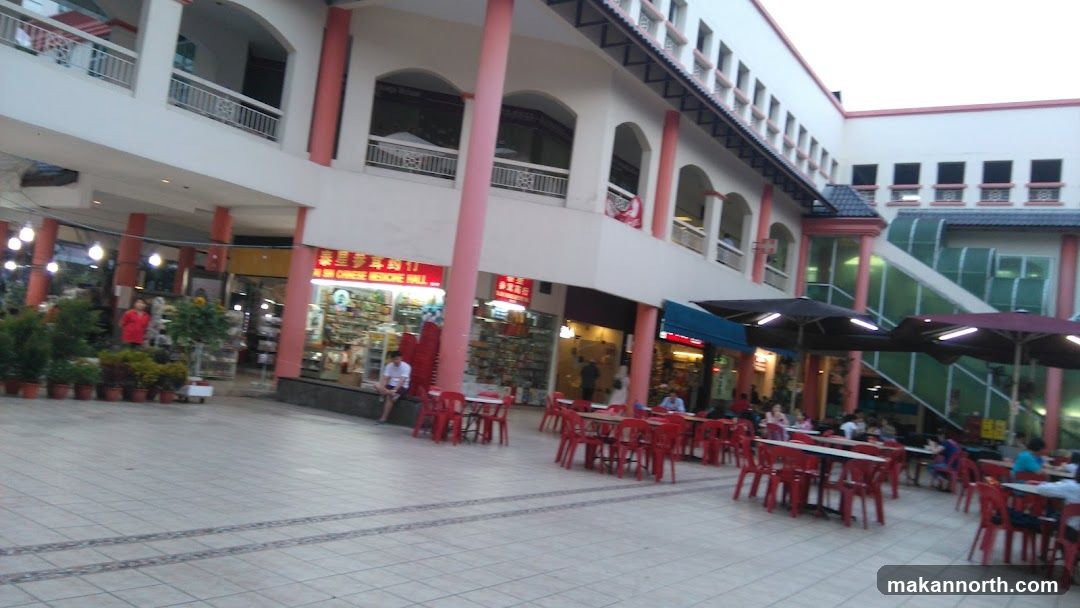 Outdoor seating area with shops in the background