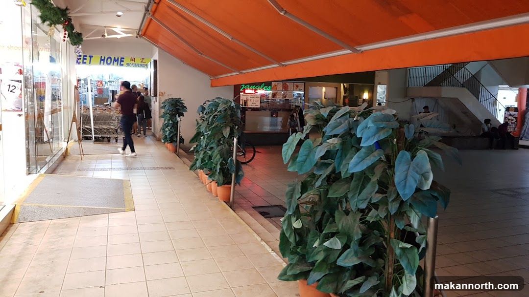 Indoor walkway with shops and plants