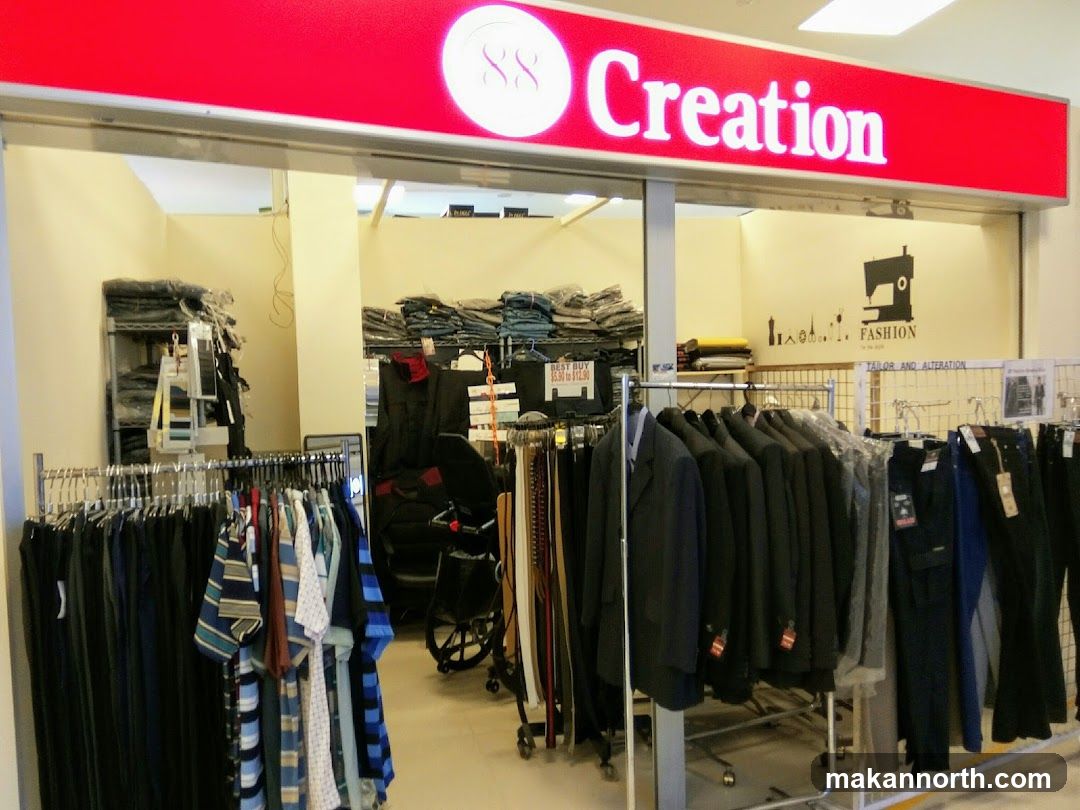The storefront of a clothing store named "88 Creation". The store offers tailor and alteration services. Racks of clothing, including suits and pants, are displayed outside the entrance. Inside, shelves are stocked with folded garments. A sewing machine graphic is visible on the wall.
