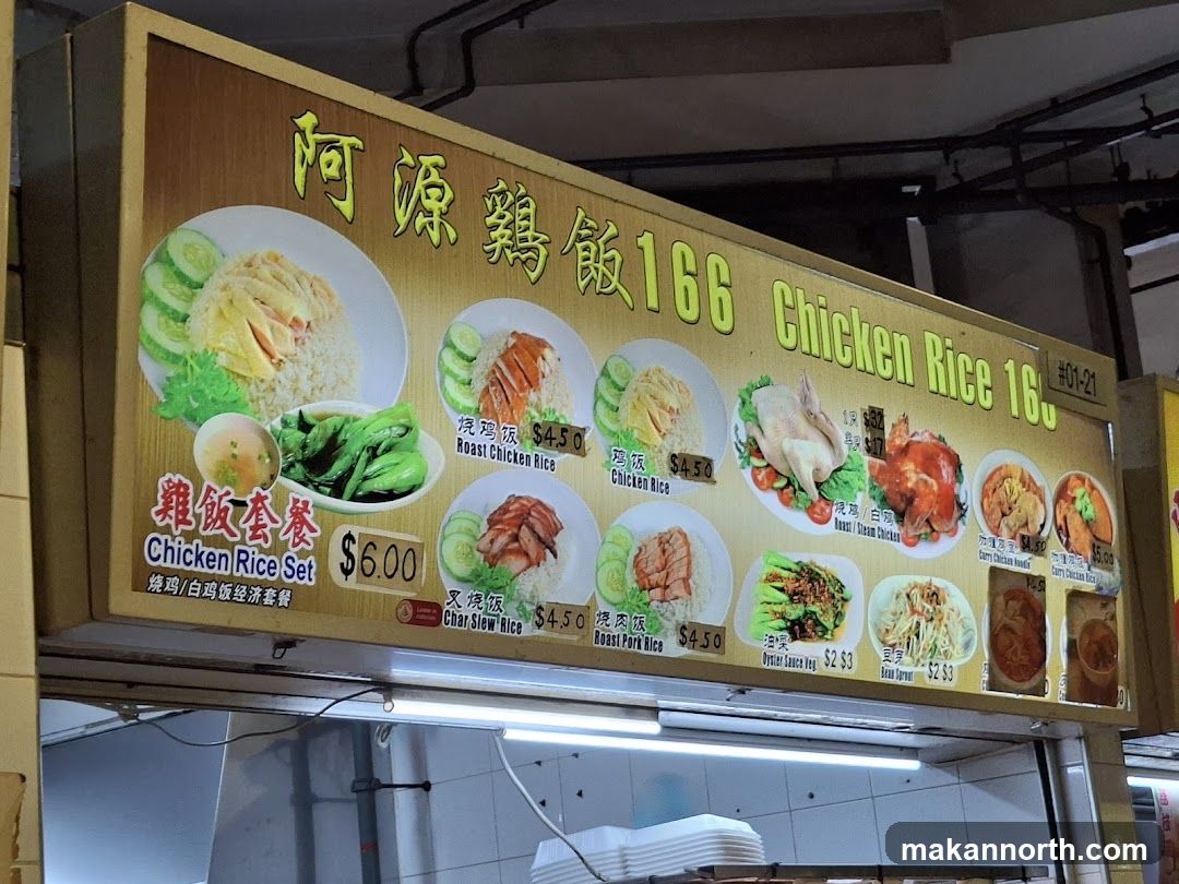 A menu board displaying various chicken rice dishes and other side dishes.
