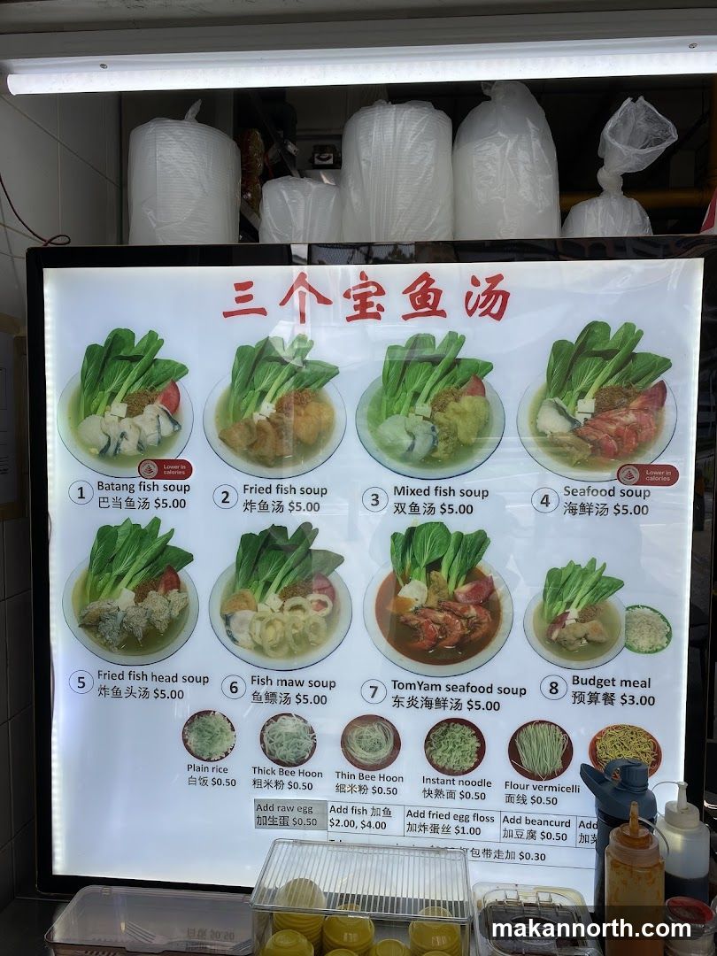 A menu board displaying various fish soup options and add-ons.