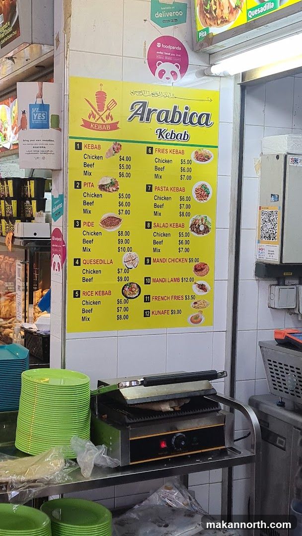 A yellow menu board with a list of kebab and other dishes.