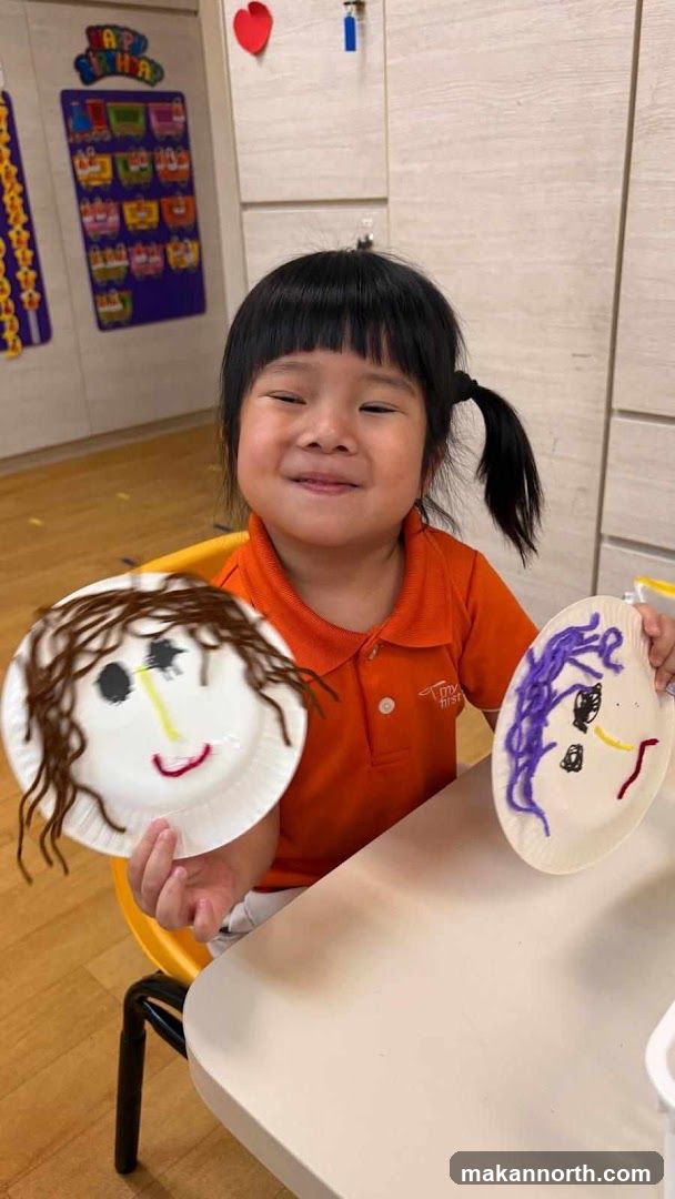 Child holding paper plate crafts