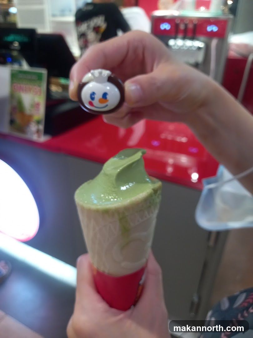 Person holding ice cream cone and character charm