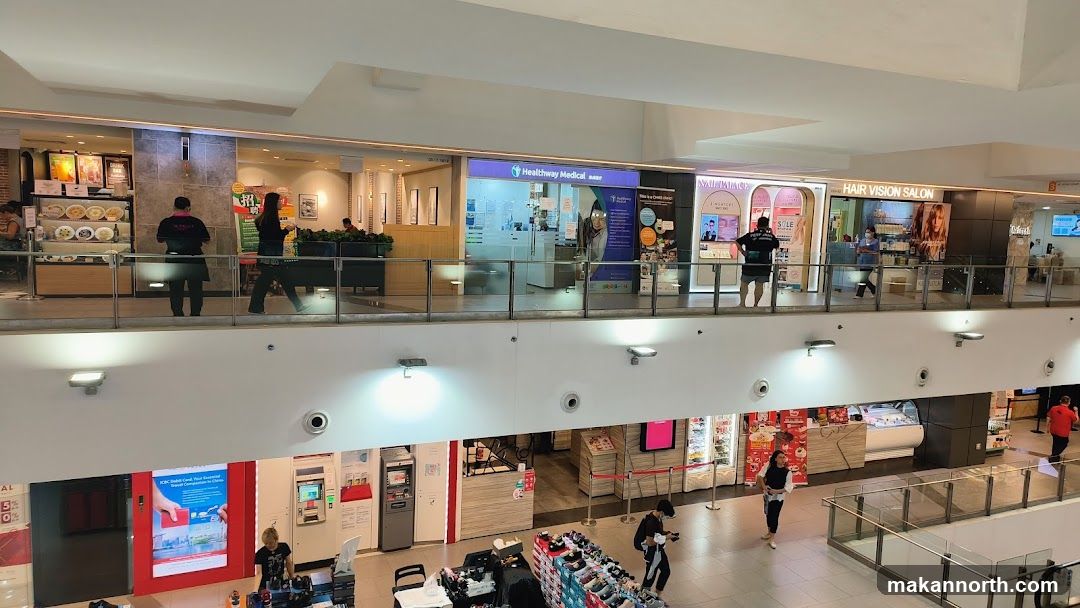 Indoor shopping mall with various shops and people