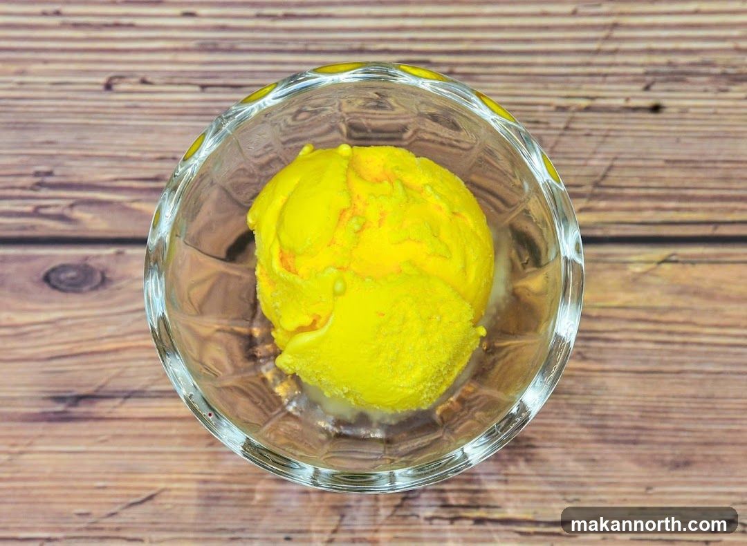 Yellow ice cream in a glass bowl