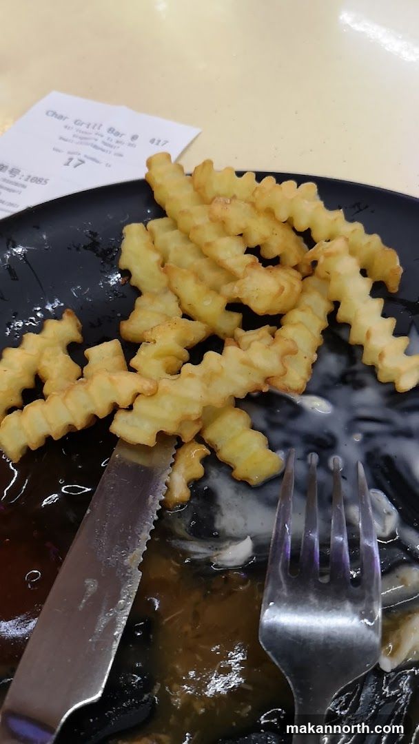 Crinkle-cut fries on a plate with a knife and fork
