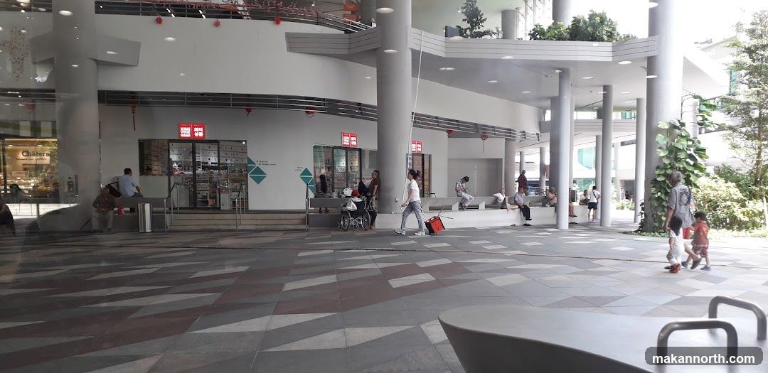 Outdoor mall walkway with shops and people