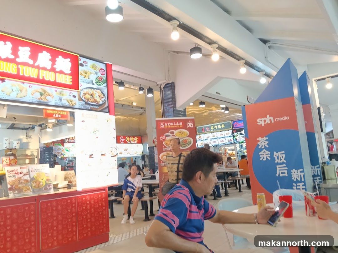 Food court with various stalls and seating areas