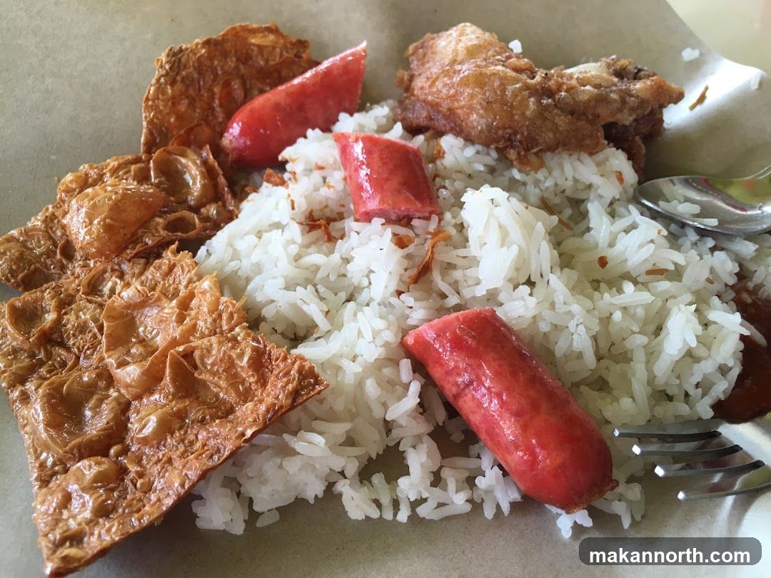 Rice dish with fried chicken, sausage, and tofu skin