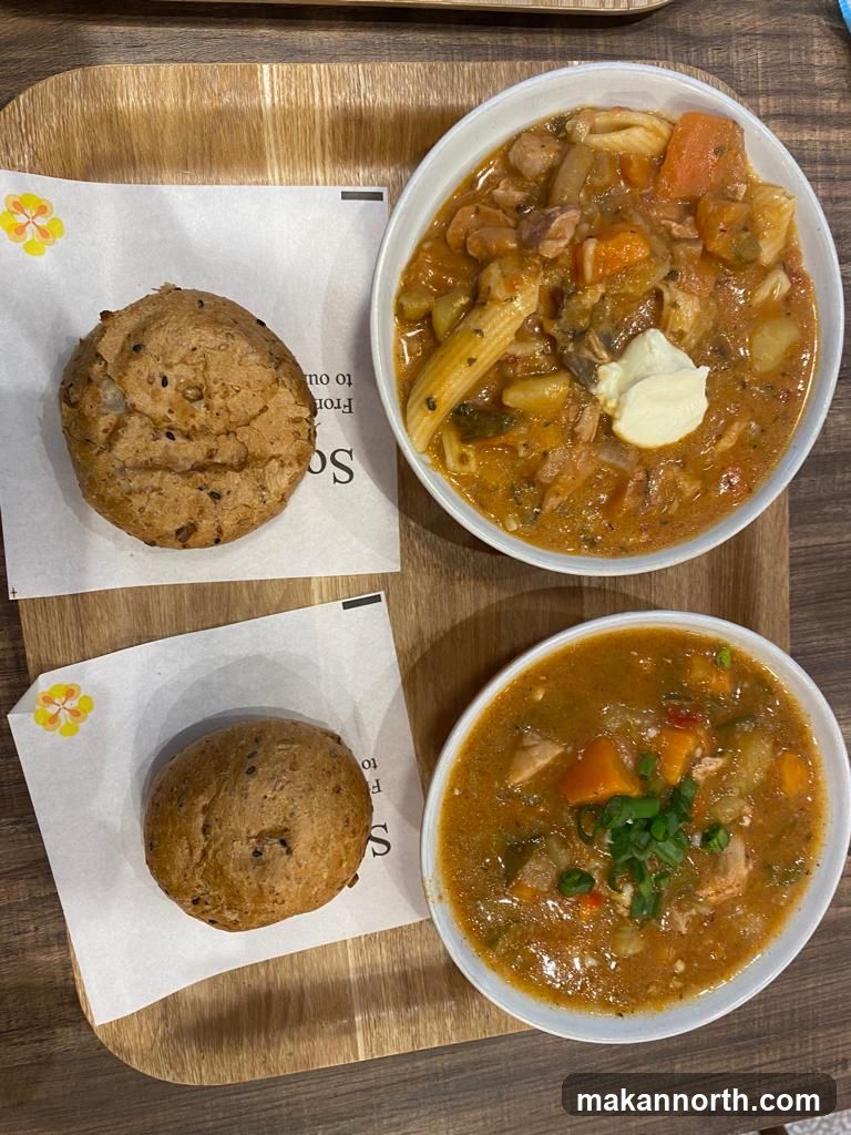 Two bowls of soup and bread rolls