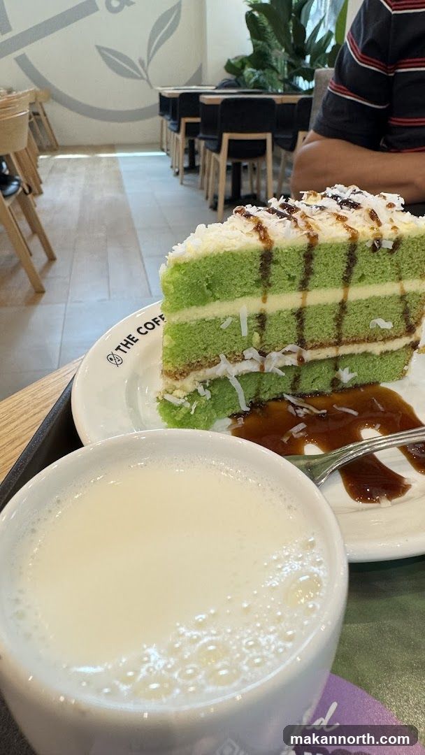 Slice of green cake with a drink