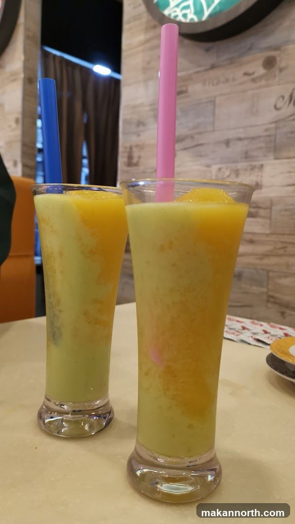 Two colorful blended drinks with straws