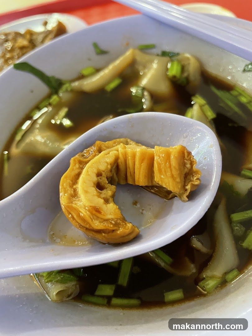 Close-up of a bowl of soup with noodles and meat