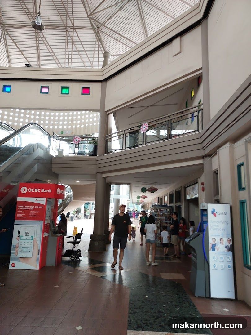 Indoor walkway with shops and ATMs