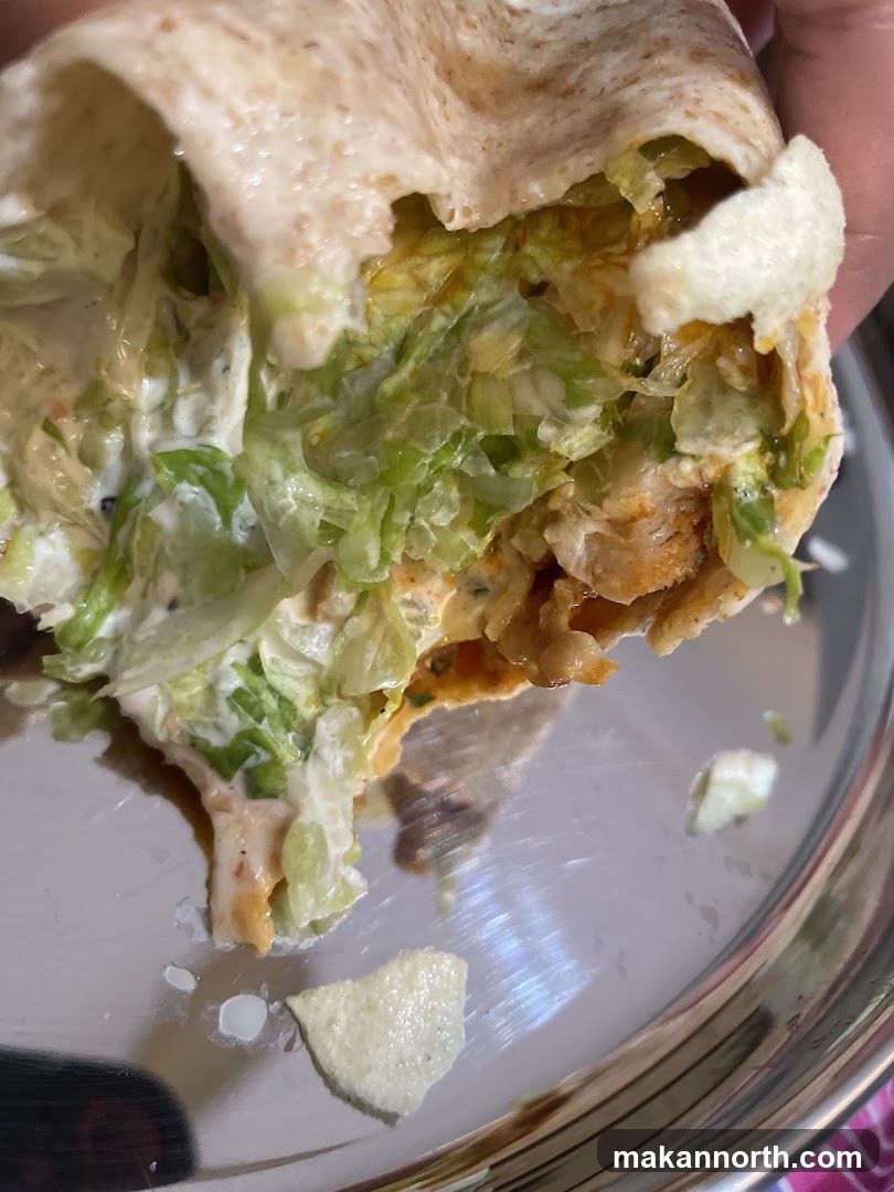 Close-up of a wrap with shredded lettuce and chicken