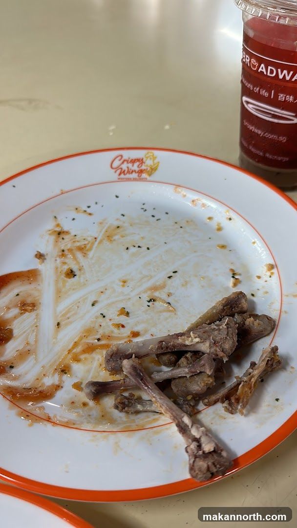 Dirty plate with chicken bones and a drink