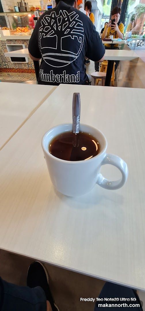 Coffee and a person wearing a Timberland shirt