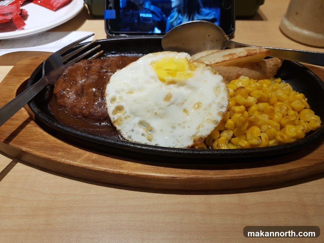 Hamburger steak with fried egg and corn