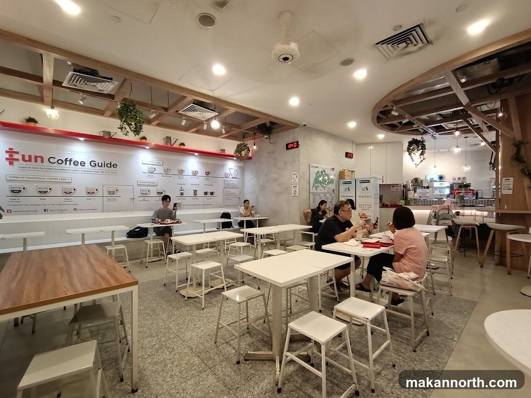 Interior of a coffee shop with seating and a coffee guide display