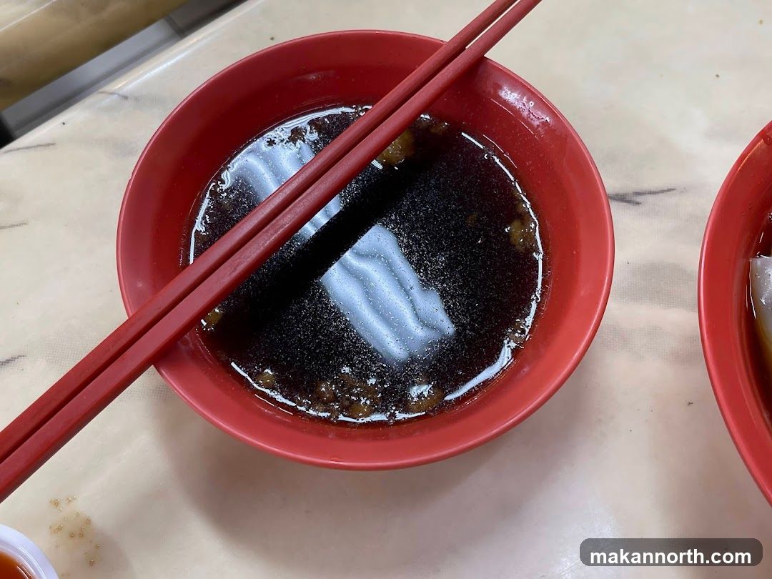 Bowl of Dark Broth with Chopsticks