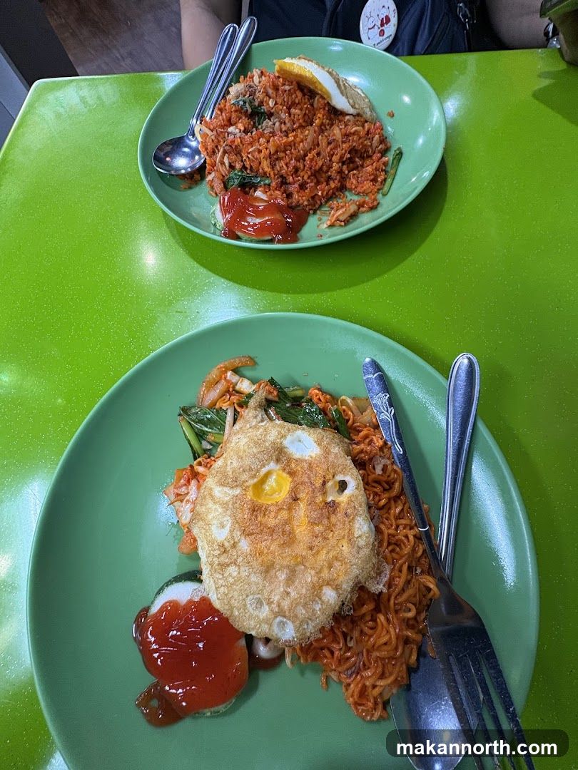Two plates of fried noodles with fried eggs