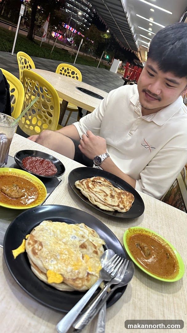 Man Eating Roti Canai with Curry