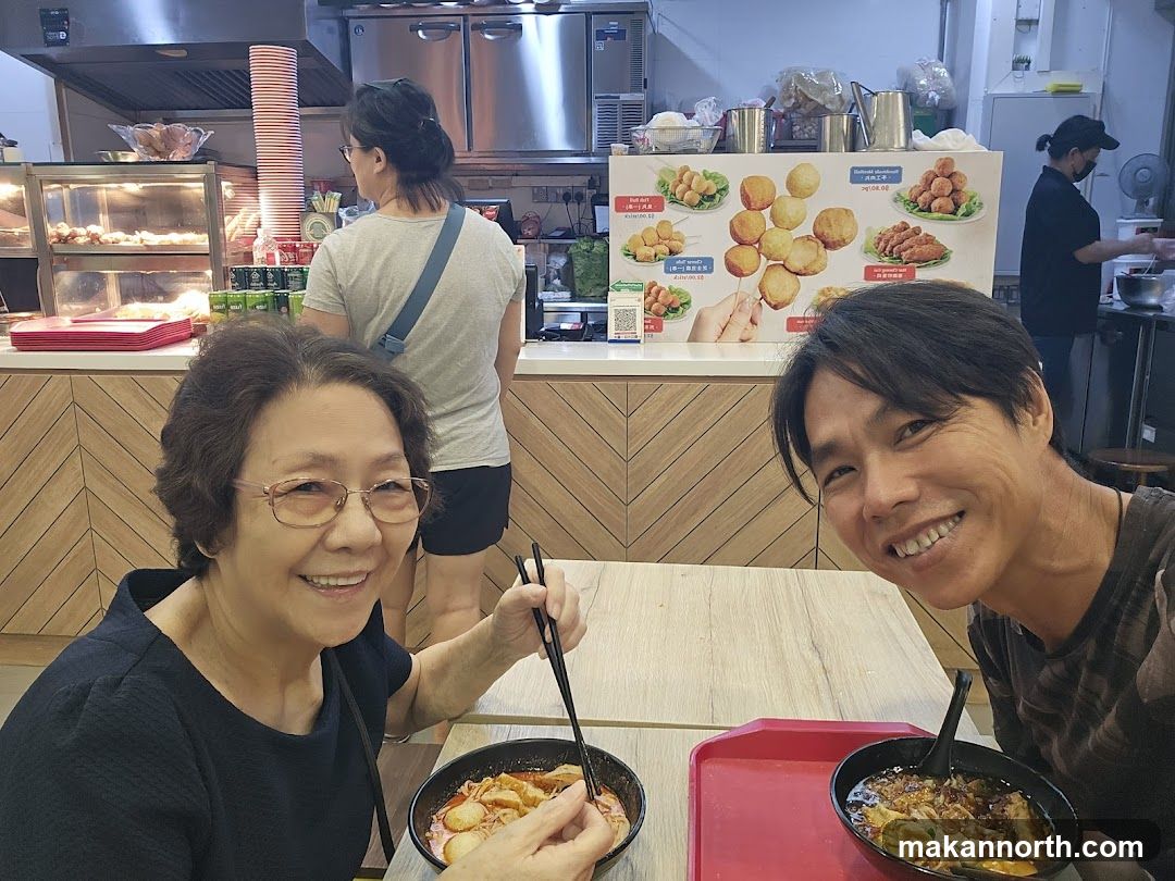 People Eating at a Food Stall