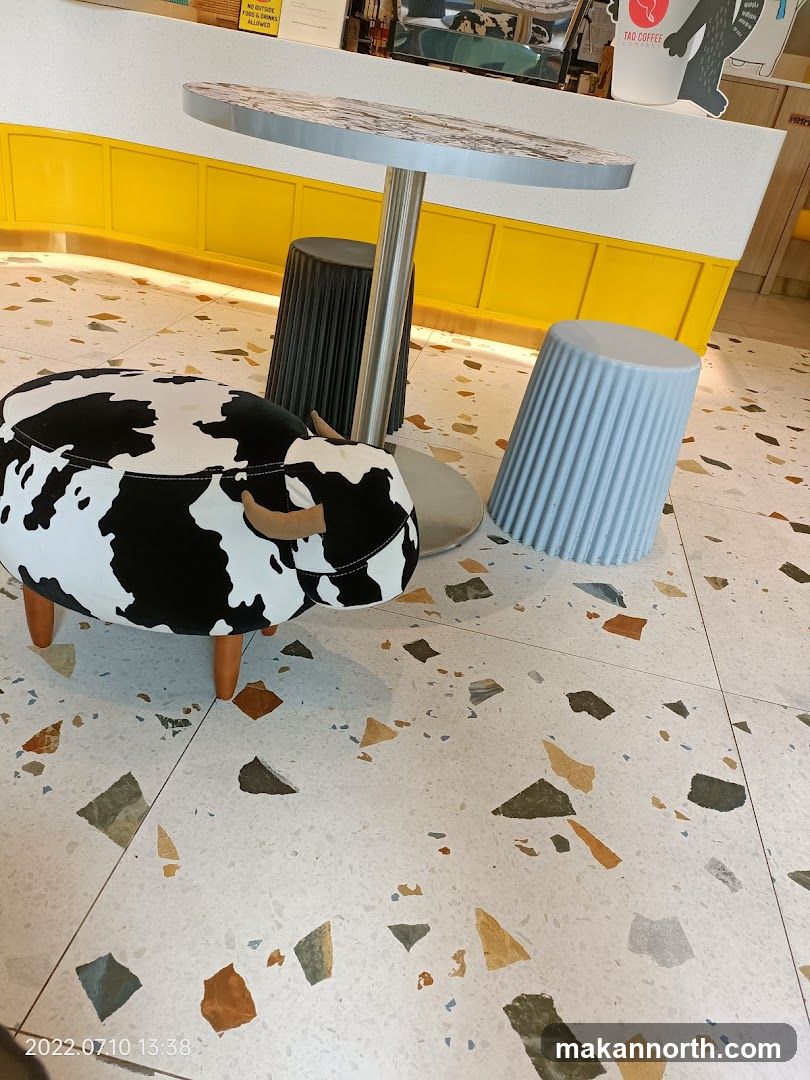 Cow-shaped ottoman and stools at a counter