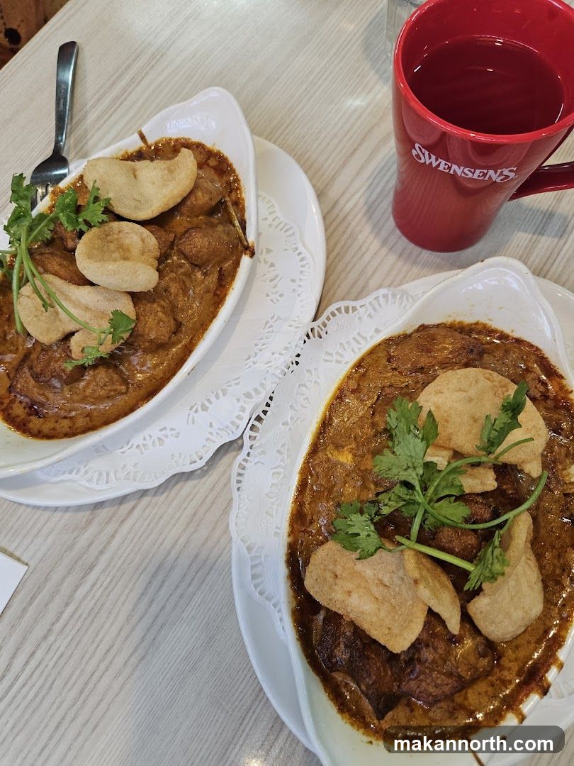 Two bowls of curry with crackers and a mug