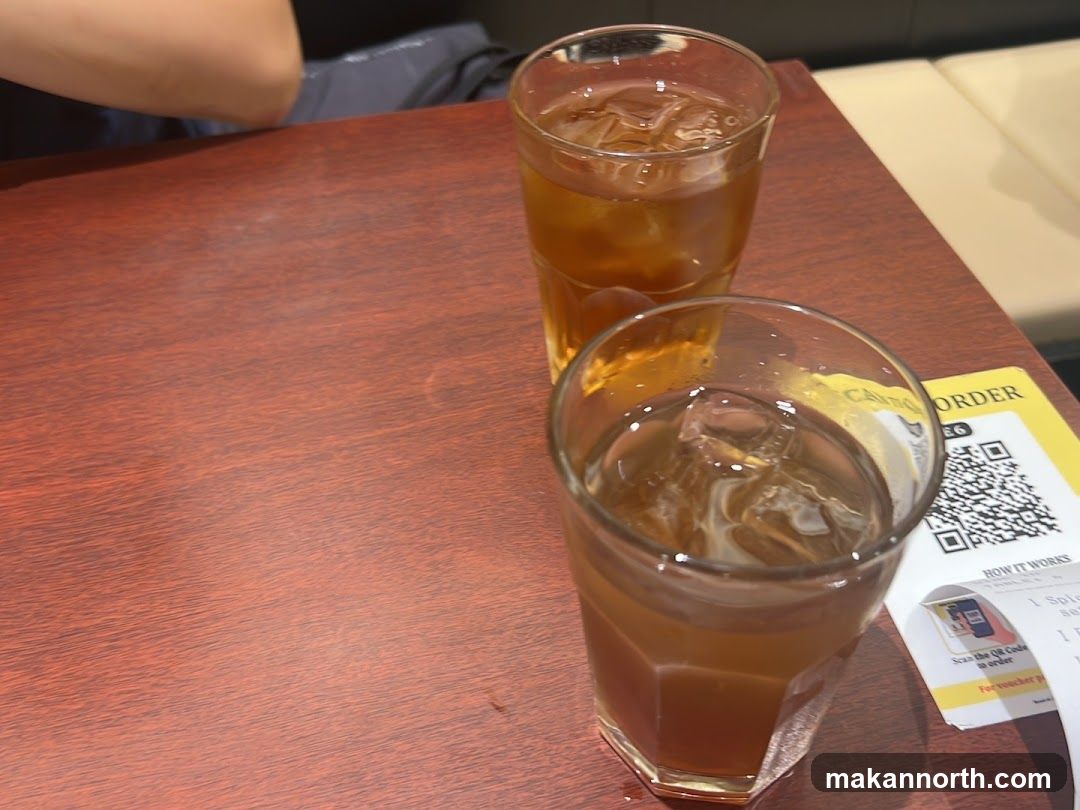 Two glasses of iced tea on a wooden table