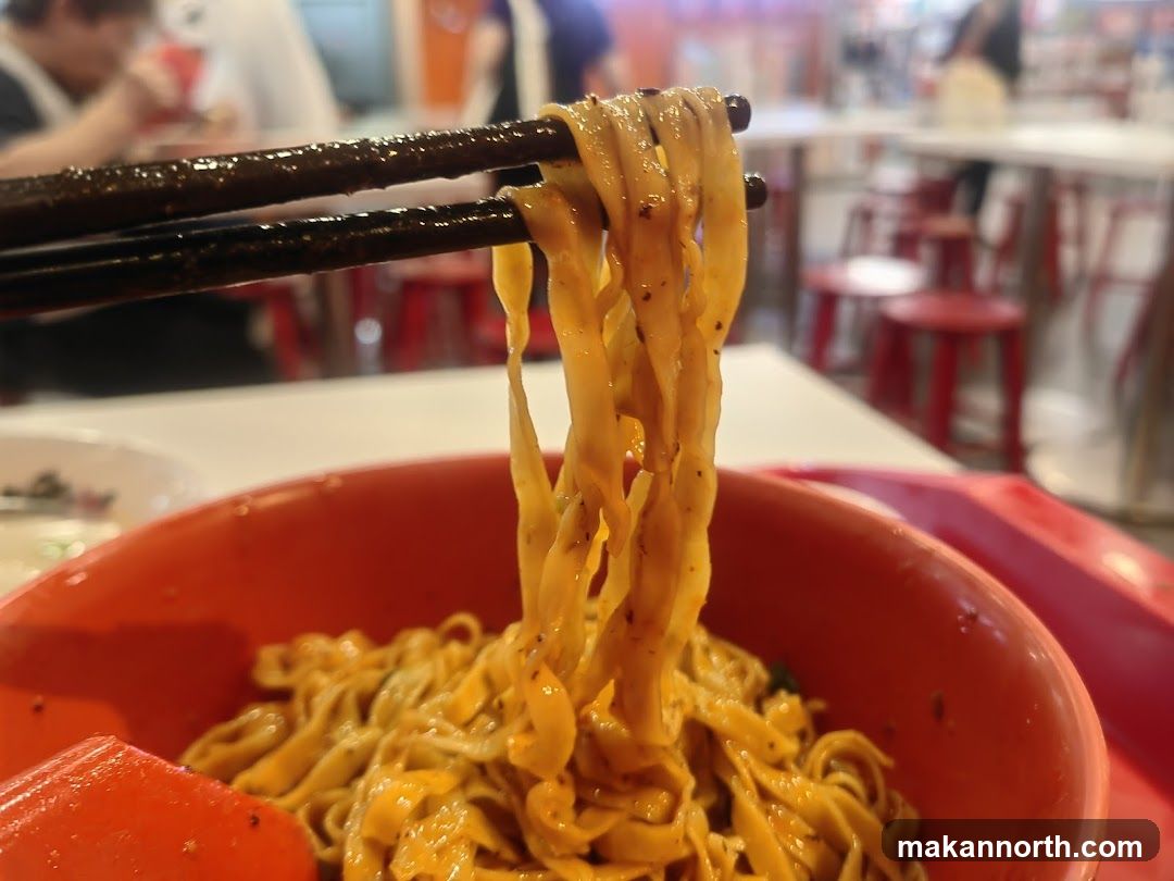 Noodles being lifted with chopsticks
