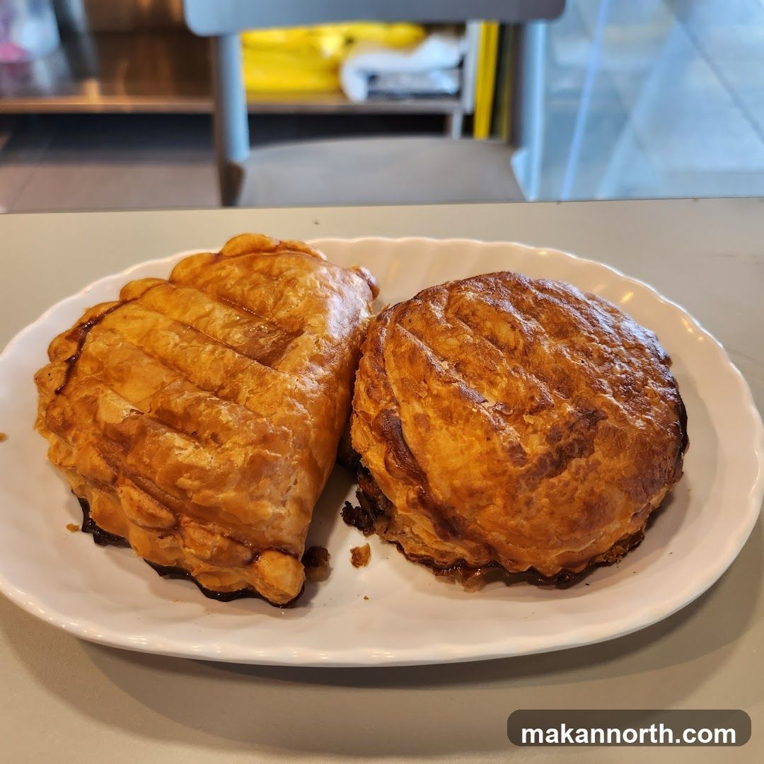 Two golden-brown pastries on a white plate