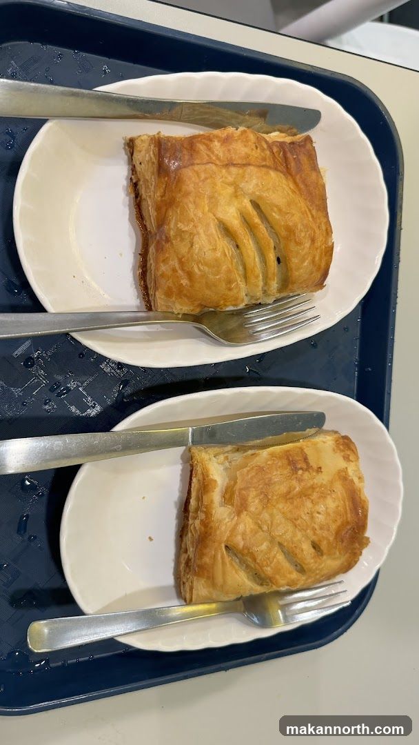 Two pastries on plates with cutlery