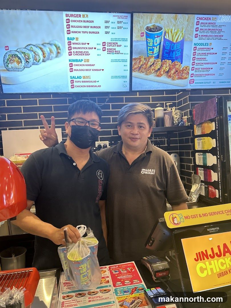 Two Men Behind a Counter with a Menu