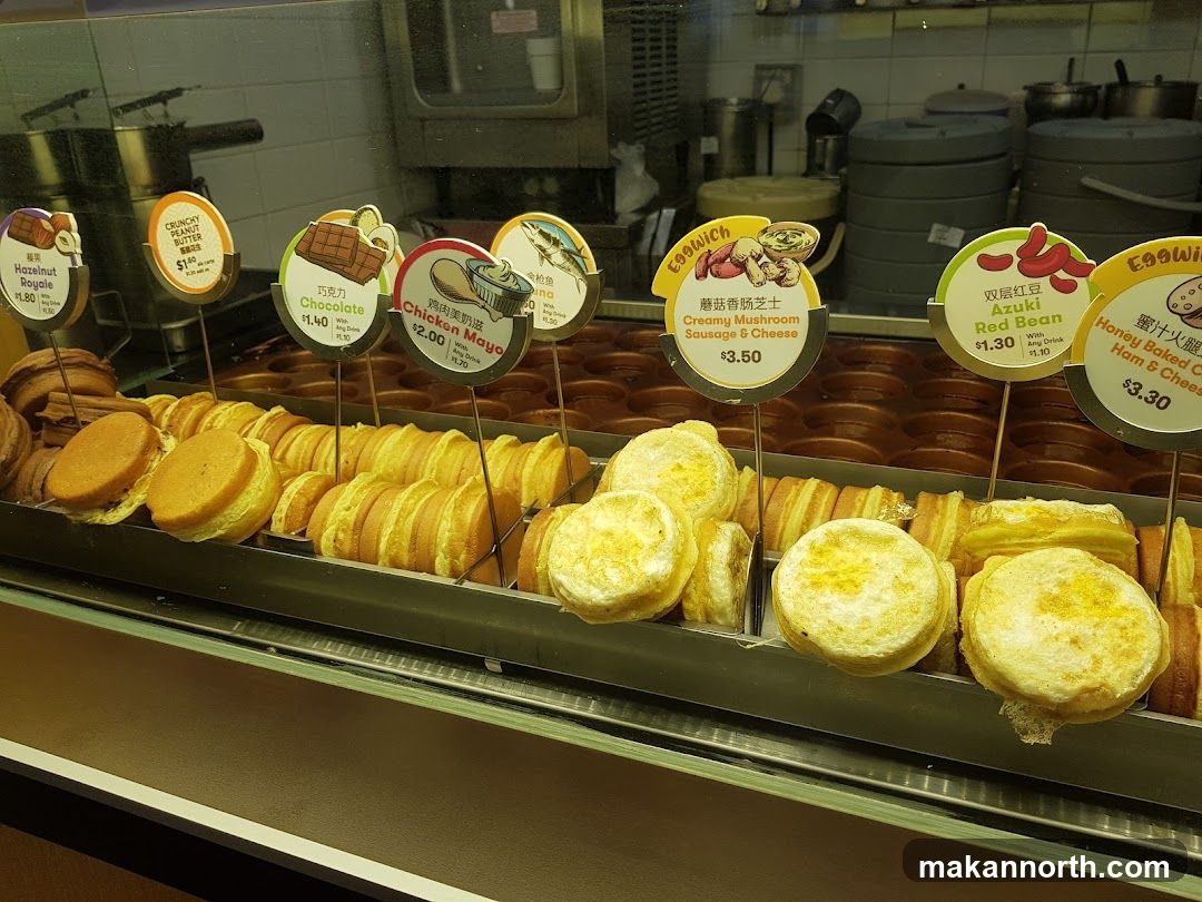 Food display with various egg sandwiches and pastries