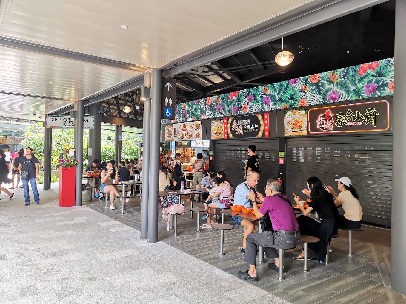 Diners at Bukit Canberra Hawker Centre under the tropical stall row